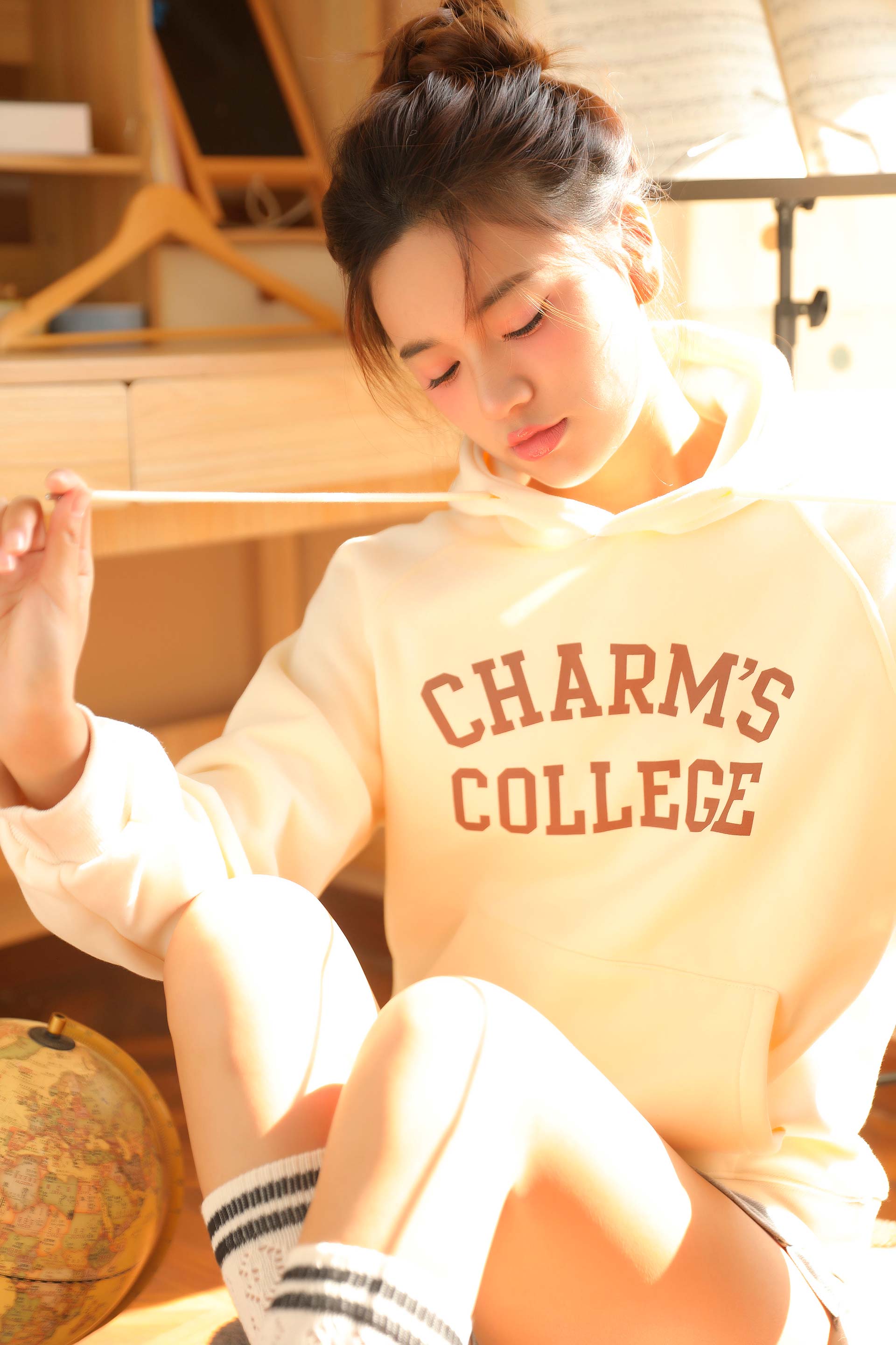 A girl wearing a Charm's College hoodie.